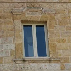Finestra in marmo chiaro cesellata con finezza dei particolari