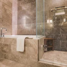 Polished brown marble bathroom with raised bathtub