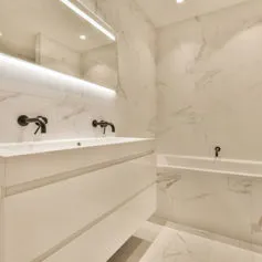 Modern bathroom in polished Statuario marble with large mirror