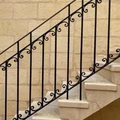 Scala a massello di pietra bianca con ringhiera in ferro