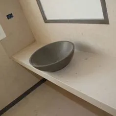 Bathroom top in beige Thala marble with dark grey Thala bowl